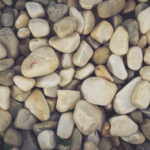 Beach stones surface. White sea pebble cobblestones texture. Marine mineral beauty harmony.