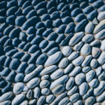 Lot of white masonry cladding pebble texture. Stones pattern background.