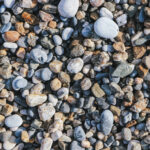 Pebble cobblestones on the beach. Nautical marine background.