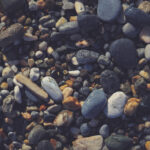 Nautical marine background. Pebble cobblestones on the beach.