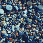 Nautical marine background. Pebble cobblestones on the beach.