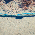 Fishnet with sinker on rope. Nautical marine background.