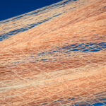 Nylon fishnet texture on the clear sky. Nautical marine background. Macro closeup.