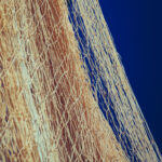 Nylon fishnet texture on the clear sky. Nautical marine background. Macro closeup.