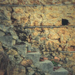 House of shell rock masonry cobblestones layers wall with stairs texture. Coquina surface background.