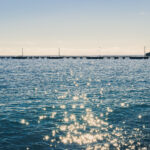 Long pier in the sea with sunshine reflection landscape.