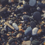 Nautical marine background. Pebble cobblestones on the beach.