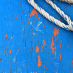 Blue painted wood texture with rope. Weathered paint wooden board. Natural wood structure background.