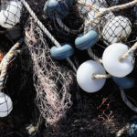 Mixed up fishnet with rope and lot of buoys texture. Nautical marina background.
